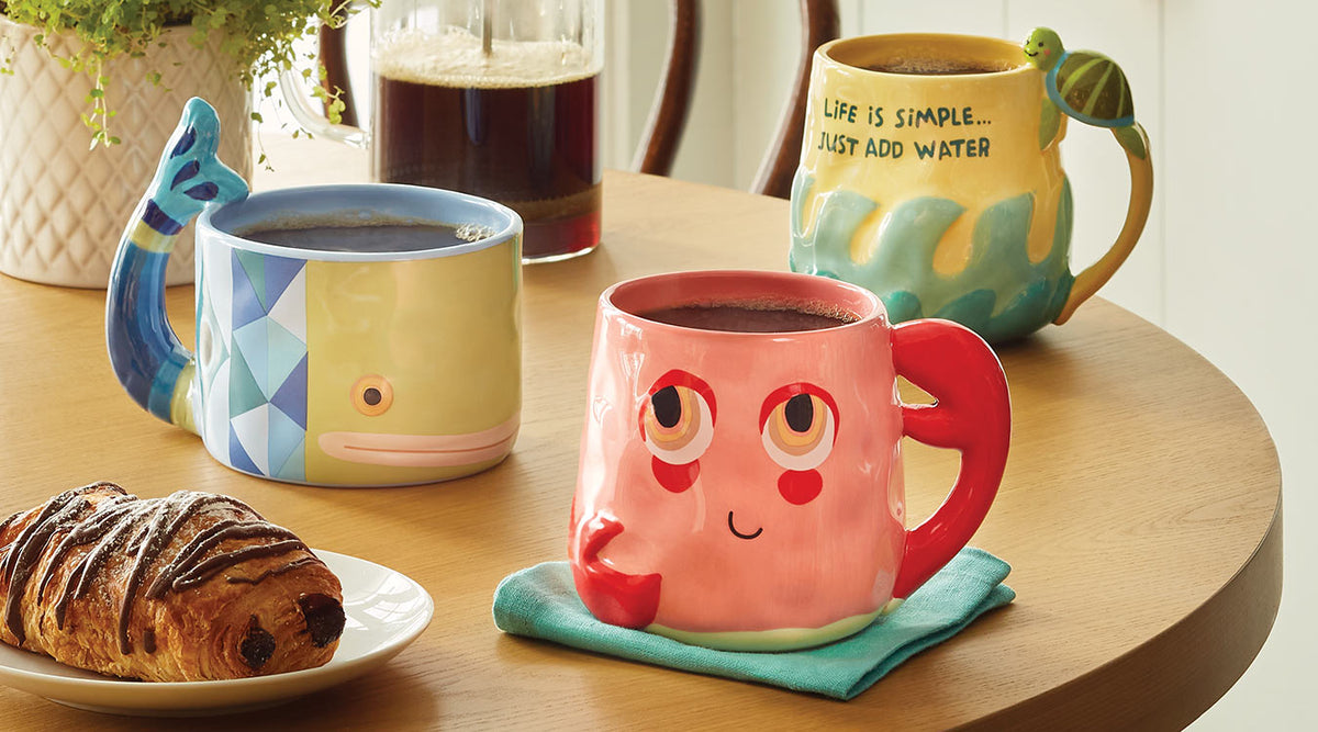Three ocean-themed mugs: A crab, a whale, and one with waves and a small turtle