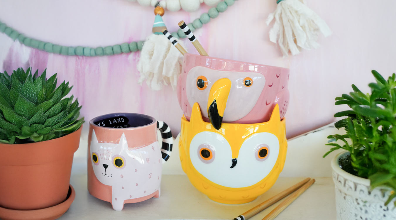 Pink cat mug next to pink flamingo bowl and yellow owl bowl